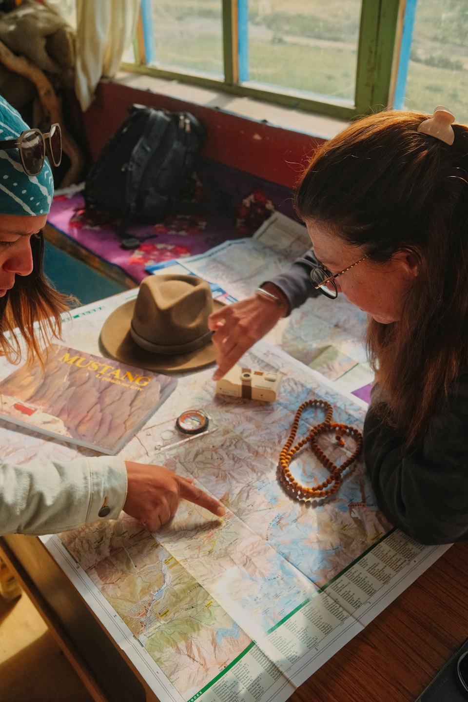 Due persone esaminano una mappa turistica su un tavolo di legno.